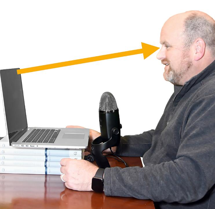 Fig 3b: Lifting the computer higher will provide a much better camera angulation and framing of the presenter. An external microphone pictured here should be positioned as close as possible between 20 - 50 cm away from your voice